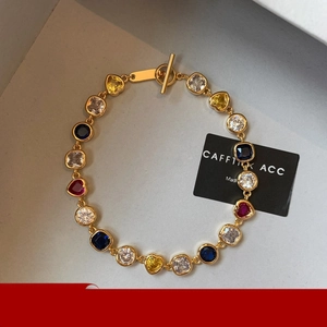 Détail d'un bracelet plaqué or 18K avec cœurs en zircon coloré et fermoir à bascule
