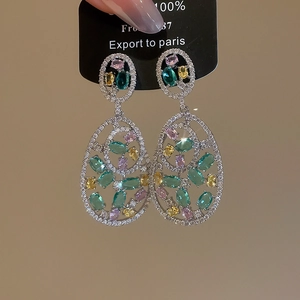 Macro detail of retro hollow oval earrings with colorful crystals and sparkling zircons