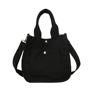 Minimalist black canvas tote bag with adjustable shoulder strap and silver snap buttons