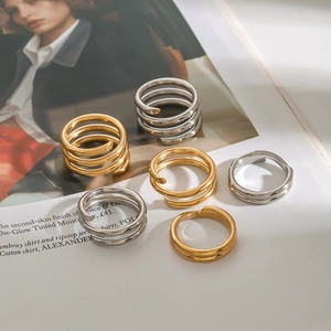 Minimalist stainless steel spiral rings in gold and silver finish on a fashion magazine