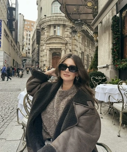 Detail of dark brown shearling jacket with turn-down collar and street style look