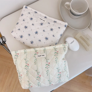 Close-up of quilted floral makeup bags with soft cotton texture and fabric labels