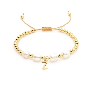 Close-up of 18K gold beads, baroque pearls, and a Z-letter charm on an adjustable cord