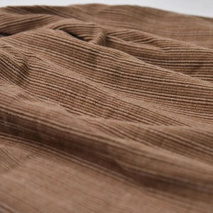 Macro shot of brown ribbed knit fabric showing detailed vertical stripe texture and softness