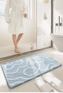 Dettaglio tappetino da bagno blu con curve bianche e trama in morbida microfibra