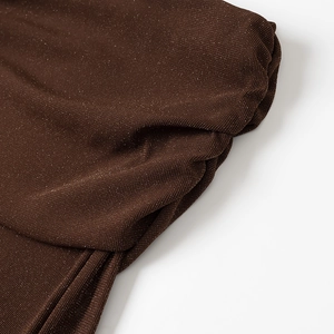 Macro shot of dark brown knit fabric with fine gold shimmer and soft texture details