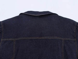 Dettaglio ravvicinato della giacca di jeans indaco scuro con cuciture arancioni a contrasto