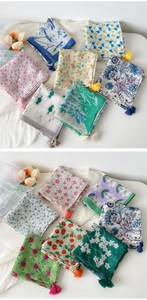 Detailed display of cotton linen square scarves with floral prints and tassel edges