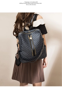 Close-up of black backpack featuring gray geometric patterns and gold zipper details