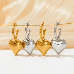 Detailed macro view of heart-shaped pendants in polished gold and silver steel finish