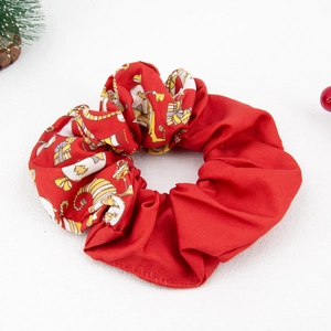 Detailed view of Christmas scrunchie with red fabric and festive cartoon print pattern