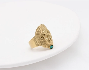 Dettaglio anello indiano vintage dorato con corona di piume e pietra verde incastonata