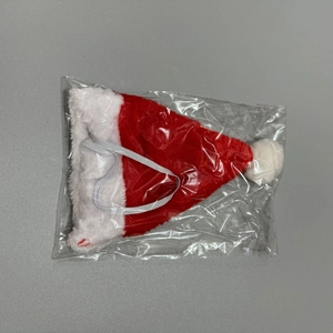 Detail view of mini plush red Christmas hat for pets with elastic strap and white pompom