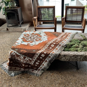 Close-up of bohemian woven blanket with geometric patterns and fringe tassels