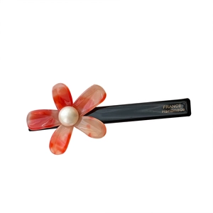 Elegant acetate flower hair clip with orange resin petals and white pearl detail