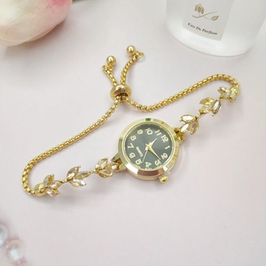 Détail du bracelet montre feuille d'or avec cadran noir et accents en cristal élégants