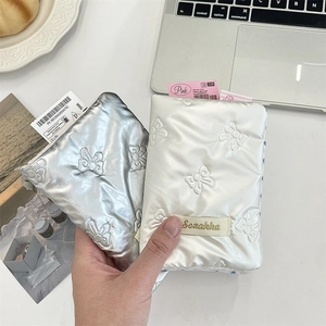 Detailed view of bow quilted passport holders in silver and cream with Sozakka label