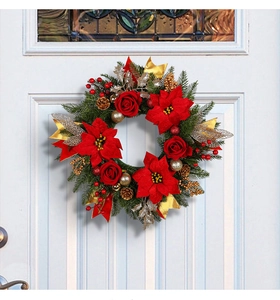 Detail of Christmas wreath with red roses, gold ribbons and pine cones on a white door