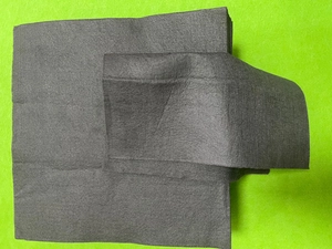 Close-up of thick black microfiber cleaning cloth texture on vibrant green background