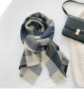 Detail of blue and beige plaid scarf with soft fringe texture and cashmere-like fabric