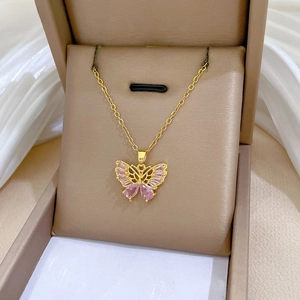 Vue détaillée du collier papillon doré avec cristaux roses dans son coffret cadeau de luxe