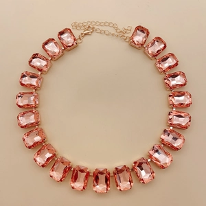 Macro shot of rectangular pink crystal stones and gold links of a statement necklace