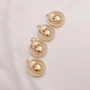 Detailed close-up of four 14K gold-filled Sacred Heart charms with cubic zirconia stones