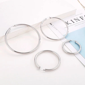 Polished silver stainless steel hoop earrings set in multiple sizes on a white background