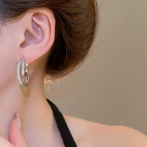 Close-up of 18k gold plated U-shaped earrings with sparkling cubic zirconia on a model