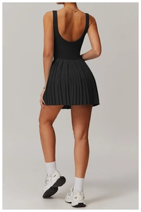 Back view of a black pleated tennis dress with a deep U-shaped back and slim fit design