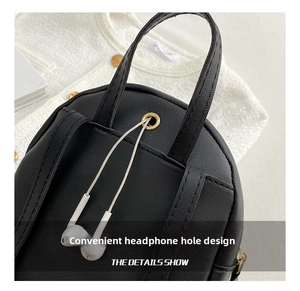 Macro view of black leather backpack featuring a functional gold metal earphone port