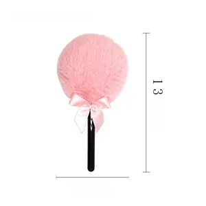 Detail of pink fairy lollipop powder puff with long soft fur and a cute silk bow