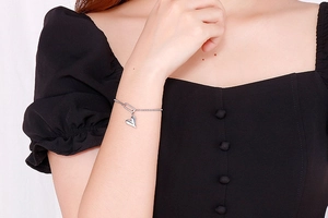 Silver heart pendant chain bracelet on model wrist with minimalist adjustable design