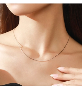 Close-up of minimalist S925 sterling silver heart snake chain necklace on model neck