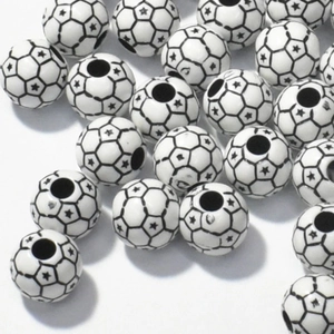 Detailed view of black and white football shaped acrylic beads with star patterns for jewelry