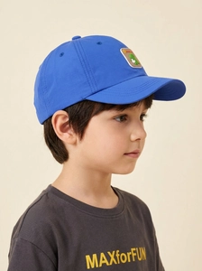 Detail of blue kids baseball cap with a green cartoon dinosaur patch and text