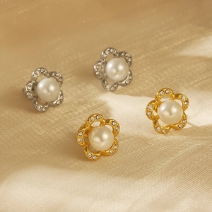 Detail of flower stud earrings with central pearl and rhinestone petals on silk cloth