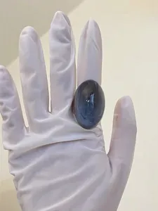 Detail of an oval blue-grey resin ring on a metal band with minimalist design