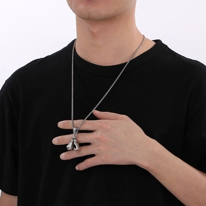 Polished silver boxing glove pendant necklace in punk hip-hop style shown on a male model
