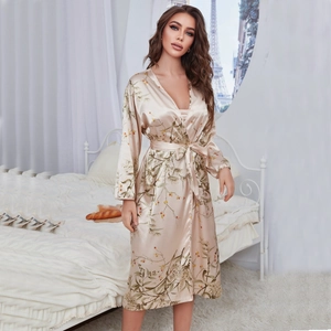 Champagne silk-style robe with floral prints and a waist tie in a Parisian bedroom setting
