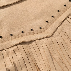Détail de la veste en daim kaki avec des franges et des finitions en perles noires