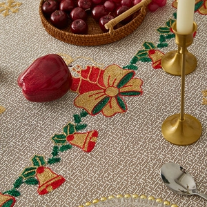 Close-up of Christmas table runner with embroidered bells and festive dining decor