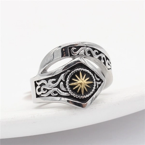 Detail of vintage steel ring with golden sun motif and black engraved patterns