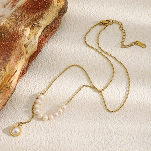 Détail du collier en acier inoxydable plaqué or 18K avec étiquette gravée K18 et perles