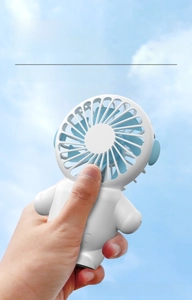 Close-up of portable astronaut handheld mini fan with blue blades against clear sky