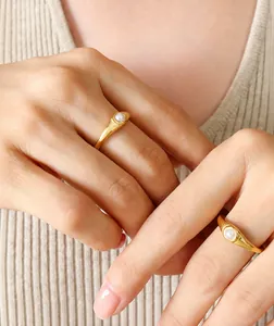 Detailansicht minimalistischer 18K vergoldeter Titanringe mit eleganten weißen Perlen