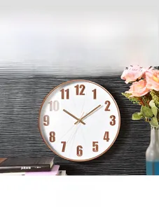 Close-up of 3D rose gold numerals on a white 12-inch silent wall clock face