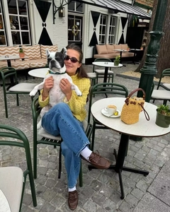 Close-up of yellow tweed jacket texture and handcrafted bucket bag in outdoor setting