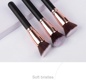 Detailed view of three professional makeup brushes with soft bristles and rose gold ferrules