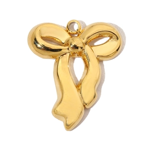 Macro shot of gold stainless steel bow pendant with a polished finish and round hanging hole